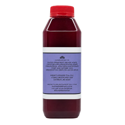 A bottle of maroon tea with a red cap and a purple label, shown on a clean white background.