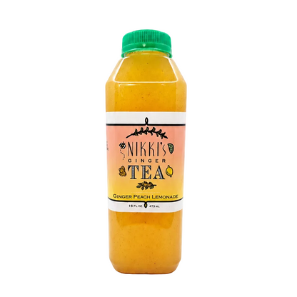 A bottle of Nikki's Ginger Tea juice with orange-yellow liquid, a green cap, and a peach and white label, centered on a white background.