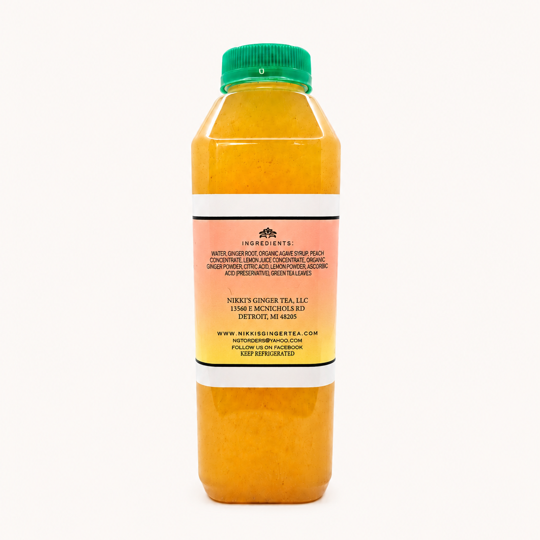 A bottle of ginger peach lemonade, showing the back of the clear plastic bottle filled with orange tea and topped with a green cap, set against a plain white background.