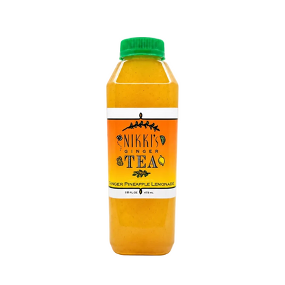 A bottle of Nikki's Ginger Tea in Pineapple Lemonade flavor, filled with a bright yellow-orange liquid, featuring a green cap and a white and orange label, set against a plain white background.