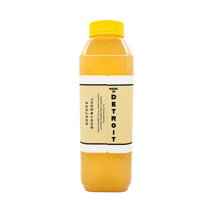 A bottle of ginger tea drink with a yellow cap and a cream-colored label, shown against a solid white background.