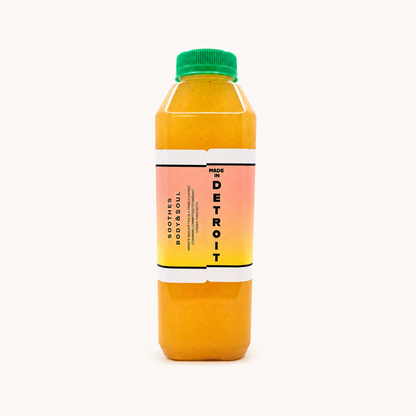 A bottle of Peach Ginger Lemonade, featuring a vibrant orange-yellow liquid inside a clear plastic bottle with a green cap and a pink-to-yellow gradient label.