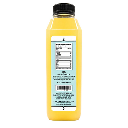 A bottle of yellow juice with a black cap, showing the back label with nutritional facts and manufacturer details, on a white background.